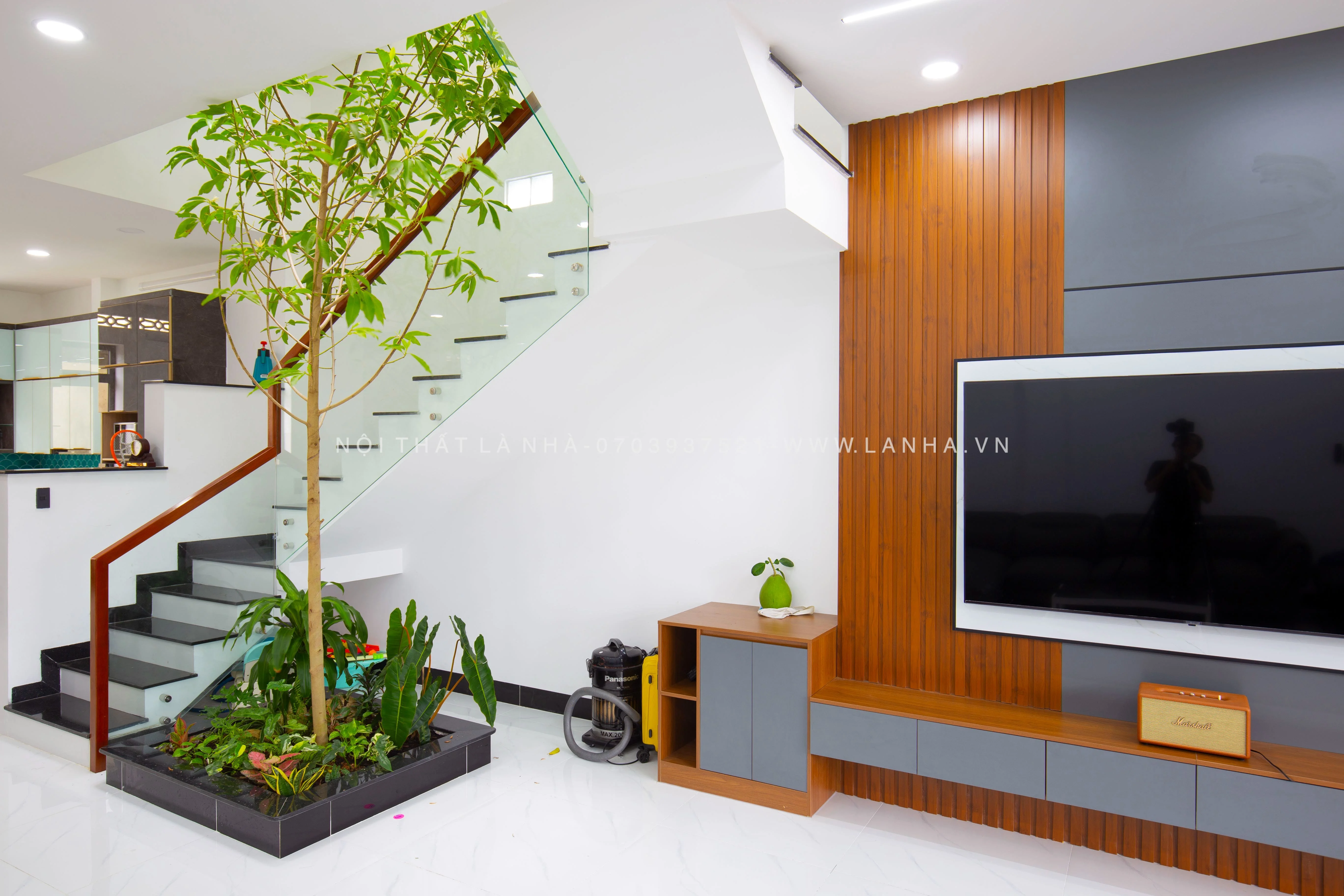 Phòng khách có cầu thang, trồng cây xanh