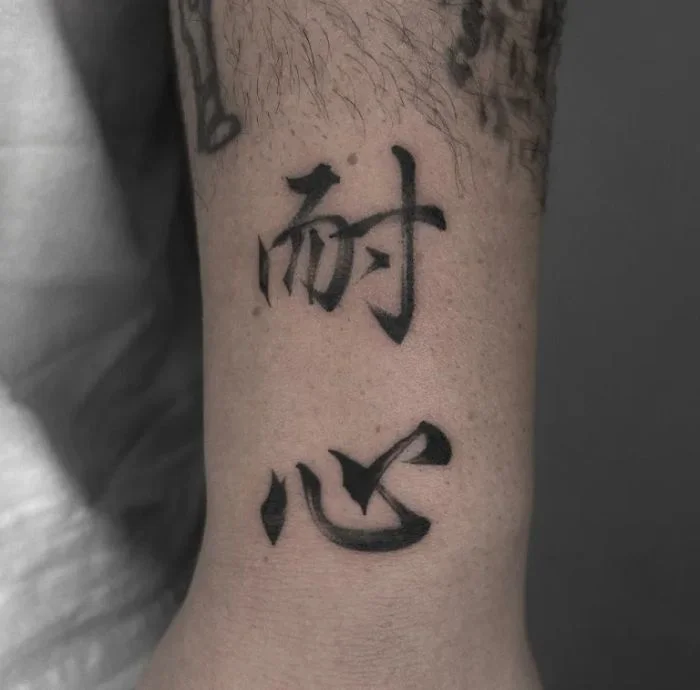 Hình xăm chữ Hán '耐心' trên cánh tay
