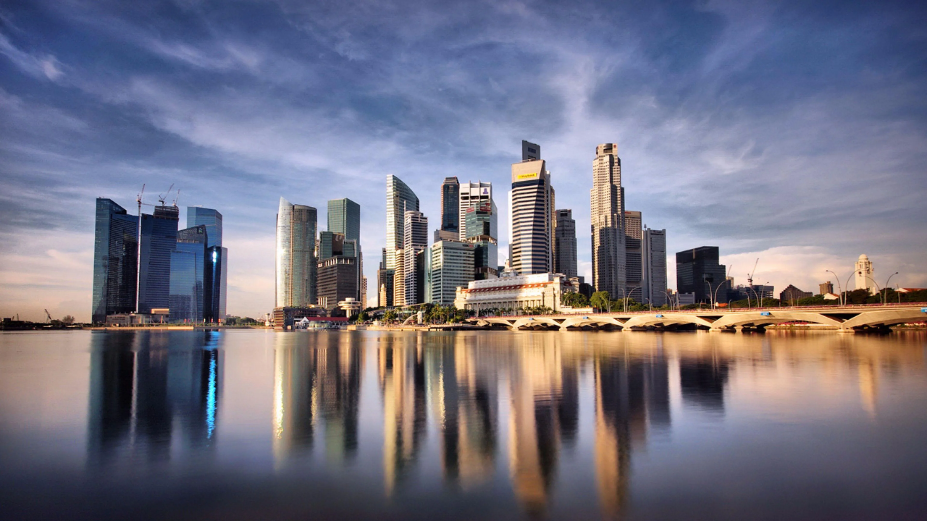 Đường chân trời Singapore bên vịnh dưới bầu trời xanh hồng và mặt nước phản chiếu