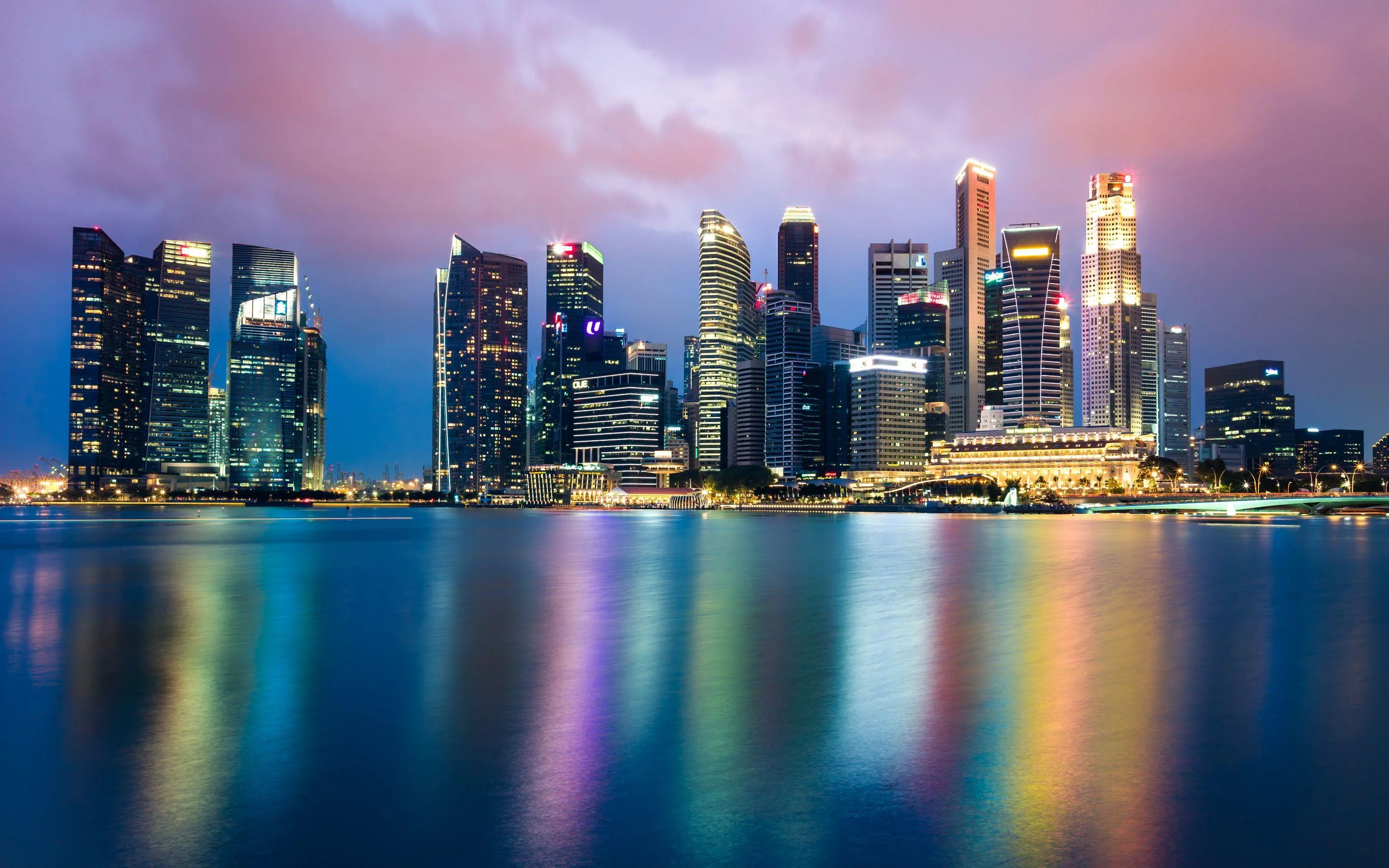 Đường chân trời Singapore bên mặt nước với ánh đèn phản chiếu dưới bầu trời hồng