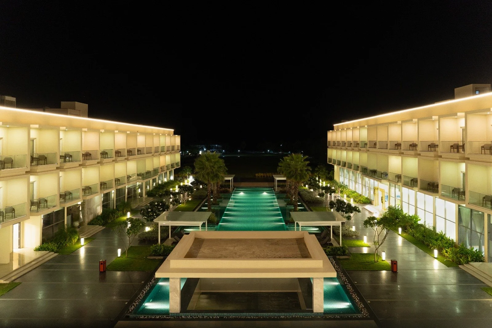 Mẫu nhà 2 tầng đẹp với thiết kế resort hiện đại, hồ bơi trung tâm và ánh đèn sang trọng vào ban đêm